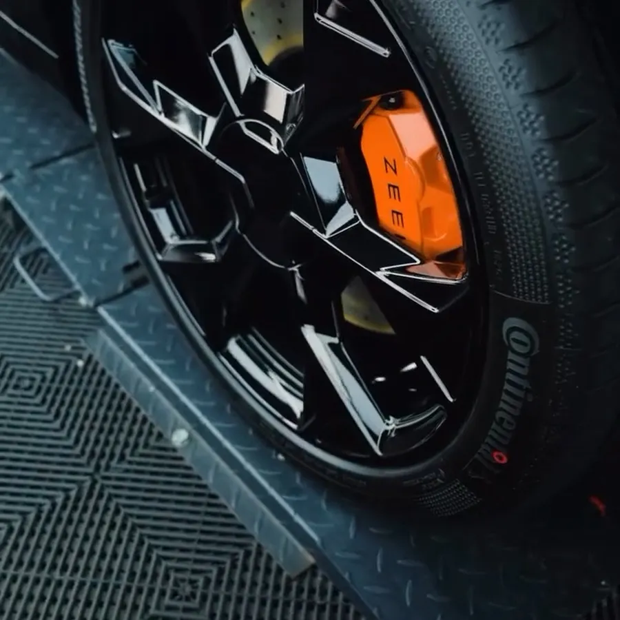 Clean black wheel, dressed tyre and orange brake caliper
